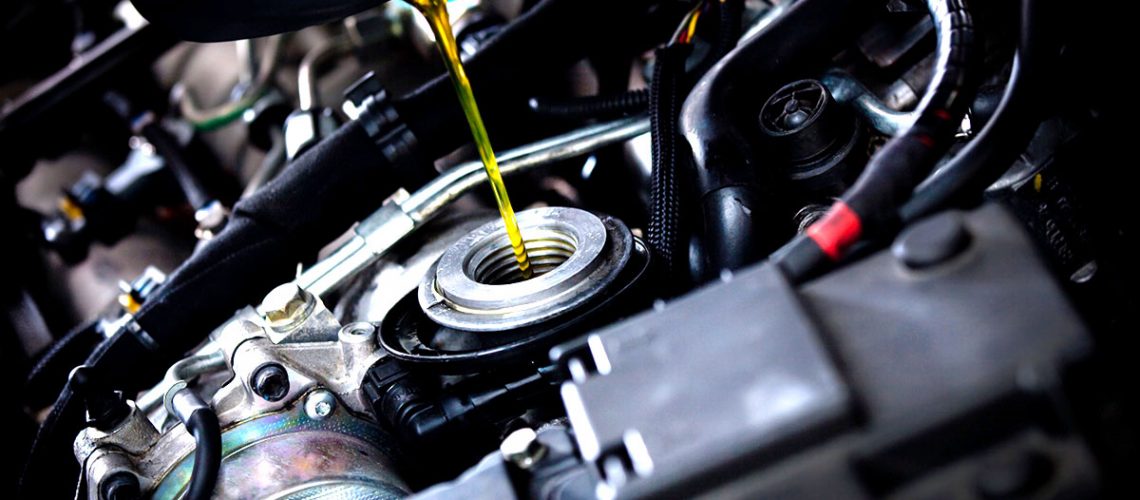Motor oil pouring into engine