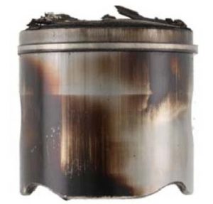 The piston crown and skirt contain deposits. Excessive deposits reduce efficiency and can lead to engine failure. 