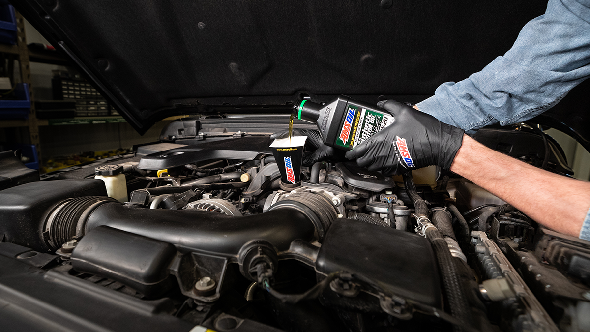 AMSOIL Signature Series 100% Synthetic Motor Oil is poured into a vehicle.