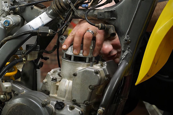 Two-stroke dirt bike top-end rebuild, installing the cylinder head.