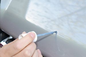 Use touch up paint to help prevent rust on a car.