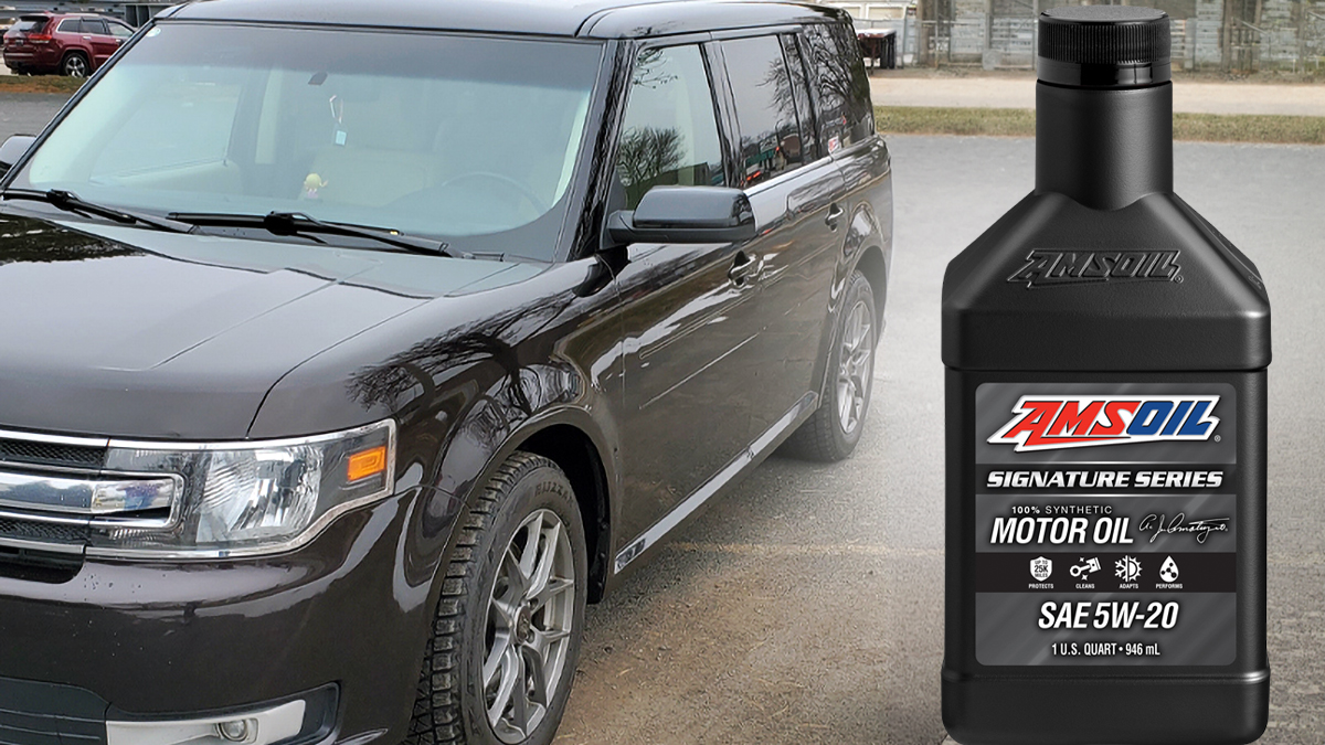 AMSOIL Signature Series 5W-20 quart next to a black Ford Flex in a parking lot