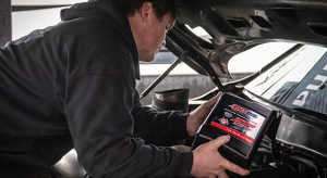 Man adds AMSOIL 100% Synthetic ATF into a vehicle. 