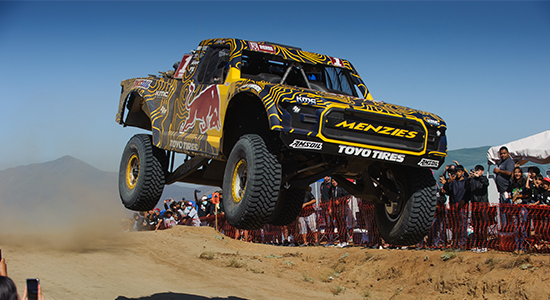 Menzies launches his truck off a large bump in the road.