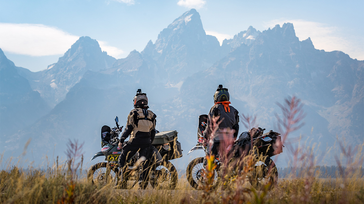 Overlanders stop with their motorcycles to take in a mountain view.
