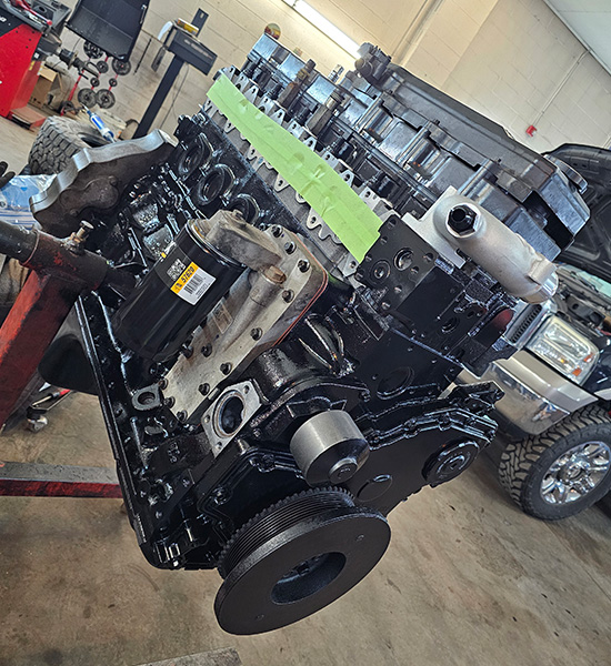 Diesel engine from RAM heavy-duty pickup truck with 500,000 miles sits on engine mount during a rebuild.