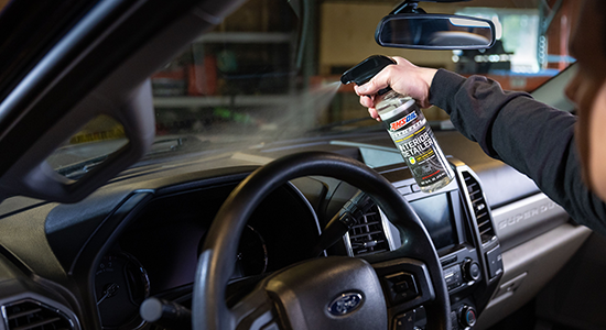 AMSOIL Interior Detailer is sprayed on a vehicle's dashboard.