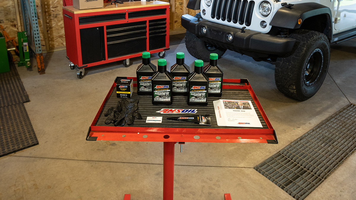 An AMSOIL Oil-Change Kit sits near a vehicle prior to an oil change.