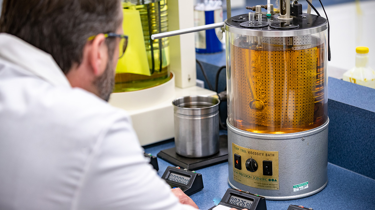 A chemist takes a readout on a sample of motor oil.