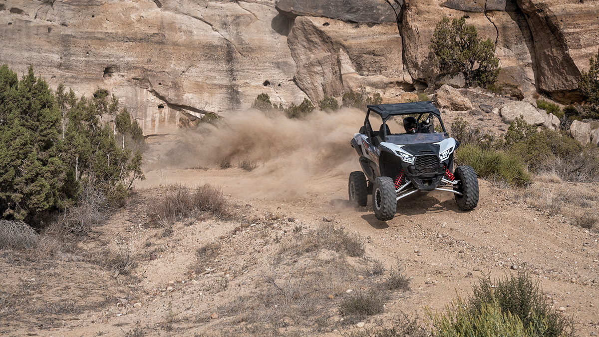 A UTV rips through a western landscape.