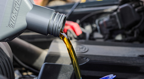 Motor oil is poured into a vehicle.