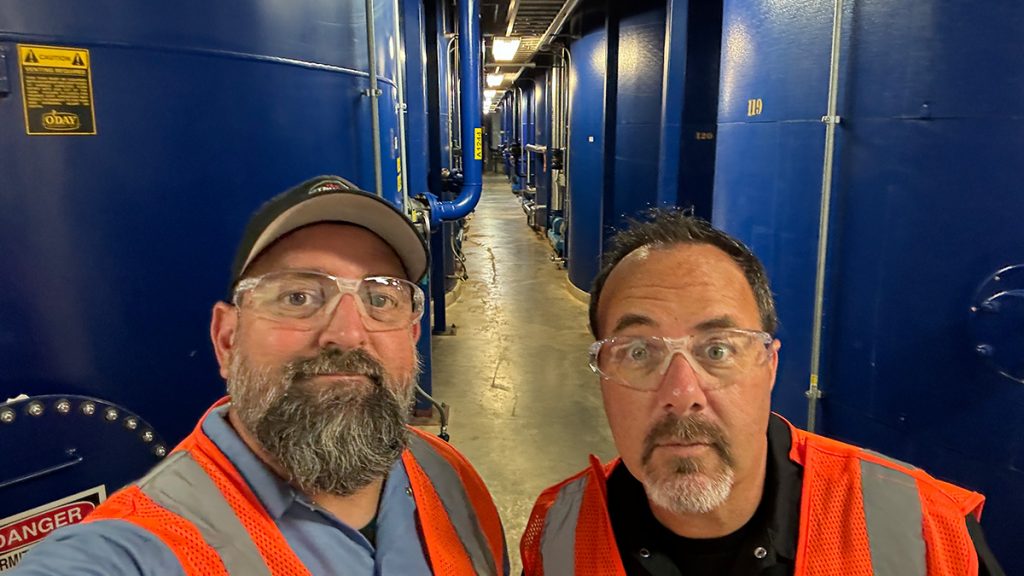 Lightning and Holman of the Truck Show Podcast stand among tanks at AMSOIL Inc. in Superior, Wis.