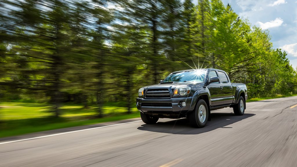A high-mileage Toyota Tacoma rolls down the road.