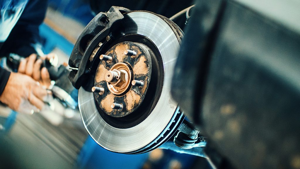 A mechanic works on a vehicle's brake system.