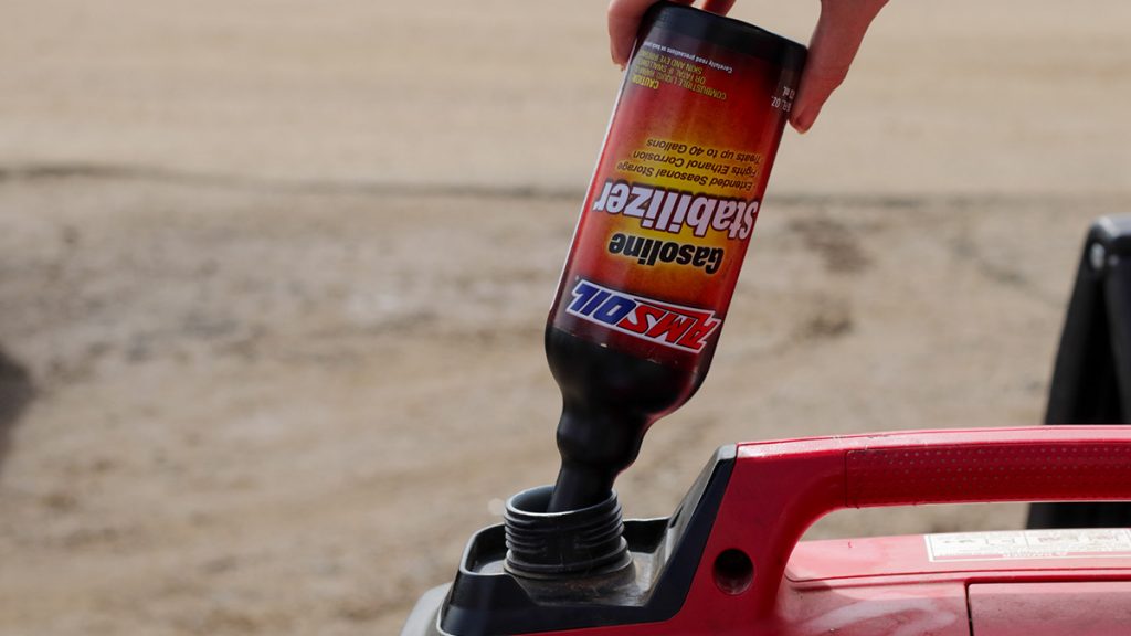 AMSOIL Gasoline Stabilizer is poured into a gas can to protect the fuel from oxidation during storage.