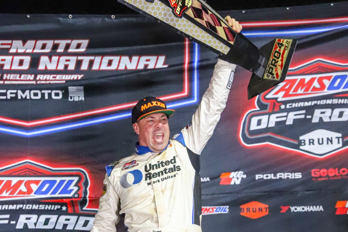 Jimmy Henderson raises the 2026 Pro 4 championship trophy on the Glen Helen podium