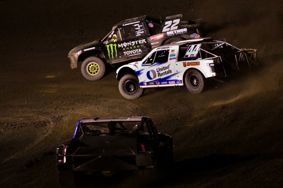 Jimmy Henderson's No. 44 Pro 4 truck races side by side with the No. 22 truck under the lights at Glen Helen