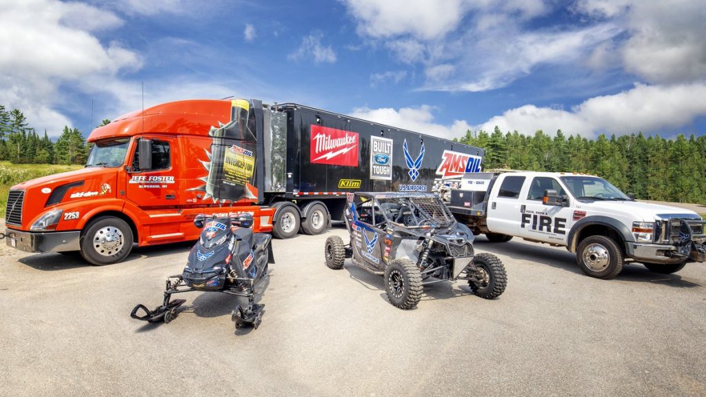 Steve Scheuring race truck and trailer parked with a snowmobile and UTV